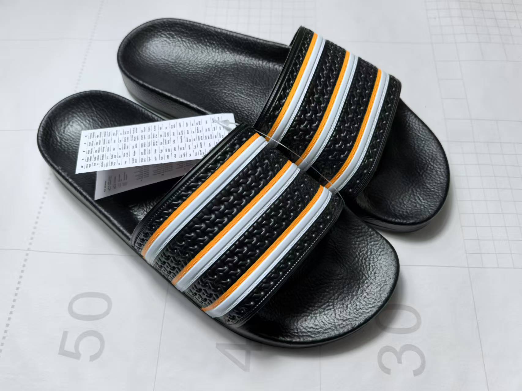 Полосатые черно-белые оранжевые шлепанцы с одним ремешком